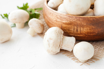 Fresh mushrooms champignon in brown bowl on white background. 