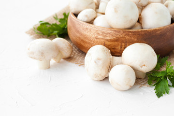 Fresh mushrooms champignon in brown bowl on white background. 