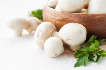 Fresh mushrooms champignon in brown bowl on white background. 