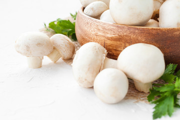 Fresh mushrooms champignon in brown bowl on white background. 