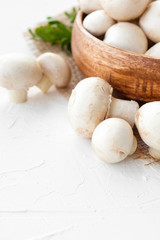 Fresh mushrooms champignon in brown bowl on white background. 
