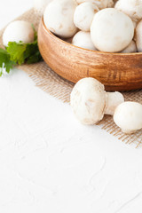 Fresh mushrooms champignon in brown bowl on white background. 