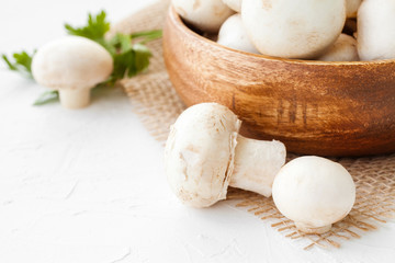 Fresh mushrooms champignon in brown bowl on white background. 