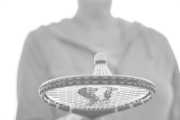 Black and white photo of senior woman with shuttlecock on tennis bat in park