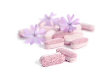 Obraz na płótnie Canvas heap of medicine tablets with flowers isolated on white background