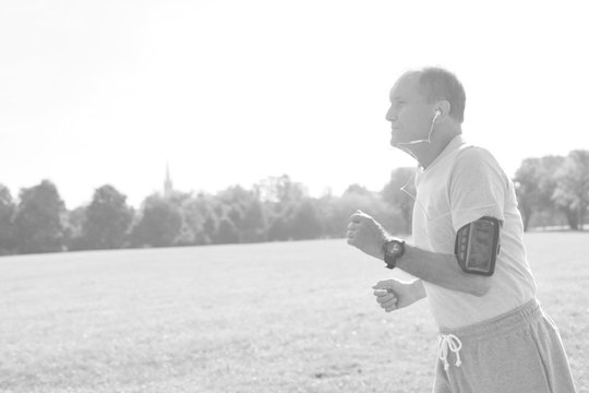 Black And White Photo Of Active Senior Man Running In Park