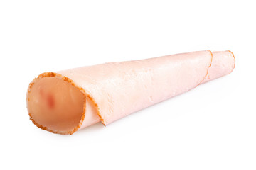 A rolled up single slice of chicken ham isolated on white.