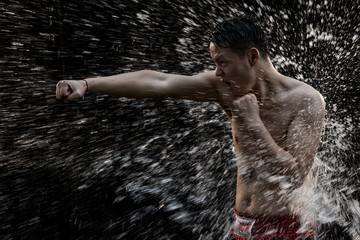 asia fighter man got into a Boxing pose with splashes of water