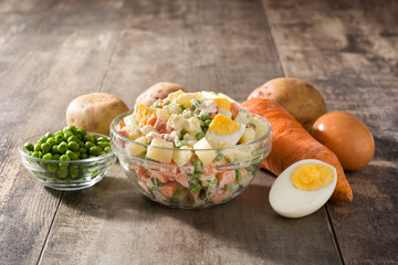 Traditional Russian salad in bowl. Olivier salad on wooden table