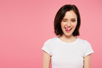 beautiful girl showing tongue and winking isolated on pink - obrazy, fototapety, plakaty