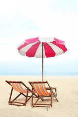 Blue sea and white sand beach with beach chairs and red parasol, Cha-am, Thailand - holiday and vocation concepts. COPY SPACE.