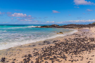 Tropical sandy beach with blue water and blue sky