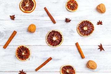 Dried orange and cinnamon, nuts on white wooden background. Flat lay