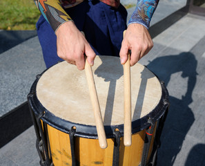 Man’s hands holding drumsticks playing Japan musical instrument taiko