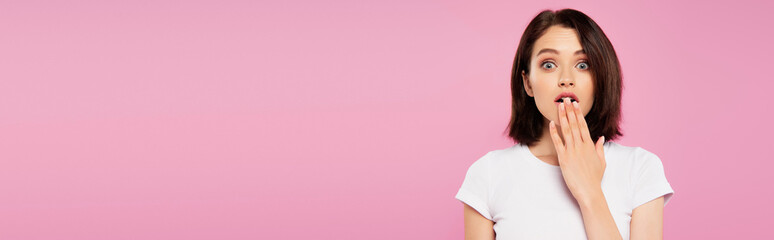 panoramic shot of beautiful shocked girl isolated on pink