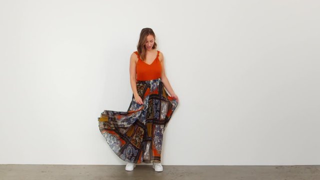 Slow Motion Shot of a Woman Swaying Her Long Patterned Skirt and Twirls Around