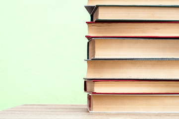 Stack of books on a wooden table.  Bright background. Education