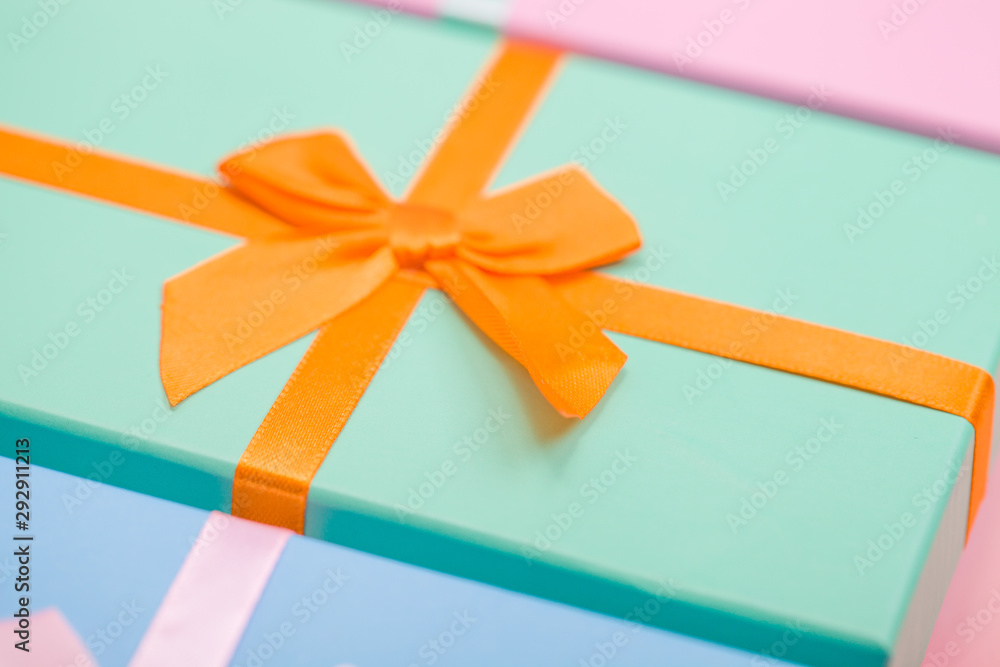 Poster multi-colored boxes with bows on a pink background
