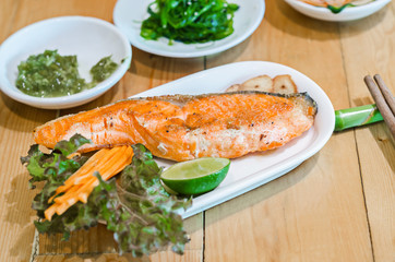 Grilled salmon with vegetables served.