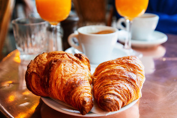 Breakfast with coffee and croissants on table