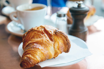 Breakfast with coffee and croissants on table