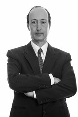 Studio shot of mature businessman with arms crossed