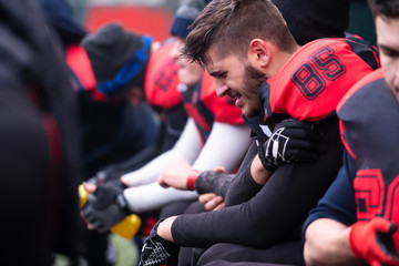 american football player holding the injured shoulder