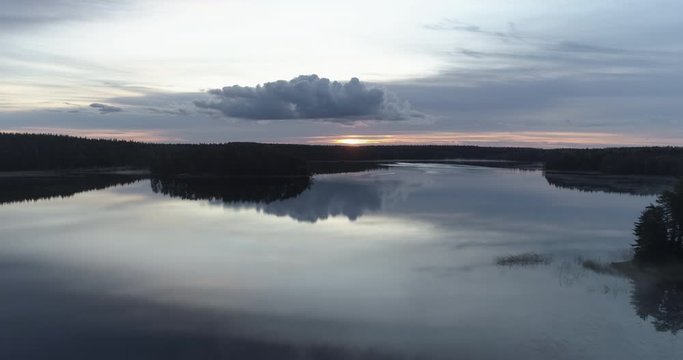 Flight over a still lake at sunrise