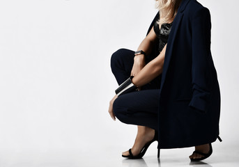 Closeup portrait of glamorous woman blonde in velvet bralet, blue jacket and pants sitting...