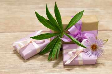 Gift boxes for Mother's Day. Flowers in a vase. Wooden table. The atmosphere of warmth and comfort