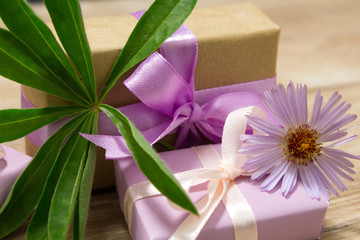 Obraz na płótnie Canvas Gift boxes for Mother's Day. Flowers in a vase. Wooden table. The atmosphere of warmth and comfort