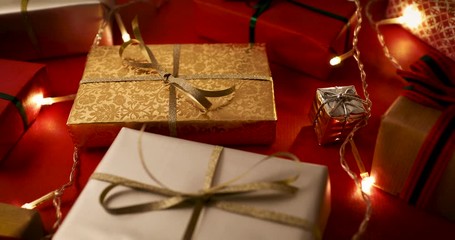christmas presents and lights on red background. dolly shot