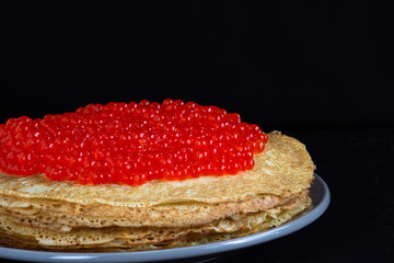Stack of porous blini with red caviar on the top