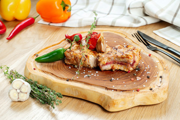 Barbecue grilled Pork Chop with hot pepper and tomato on a wooden board. CLose up. Selective focus