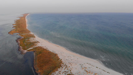 Panoramic view of coastline surrounded by sea. Drone view blue sea and sandy beach. Amazing place for summer vacation.