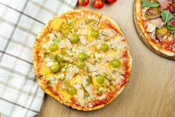 Italian, homemade 4 cheese pizza with pear and grapes on a wooden table. Top view food with copy space. Flat lay