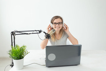 Radio, blogging, podcasting concept - young woman working as a dj on the radio.