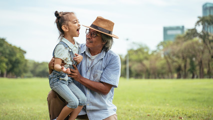 Grandfather and grand daughter enjoying sunny garden holiday together, outdoors space, leisure...