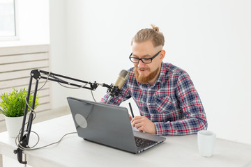 Blogger, streamer and people concept - Funny young man DJ working on the radio