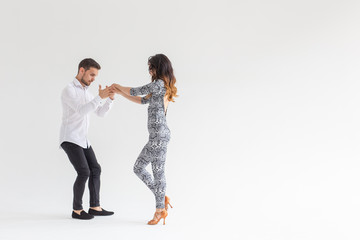 Young couple dancing social latin dance bachata, merengue, salsa. Two elegance pose on white...
