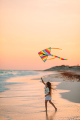 Little running girl with flying kite on tropical beach. Kid play on ocean shore. - 292926639