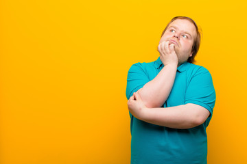 young big size man feeling thoughtful, wondering or imagining ideas, daydreaming and looking up to...