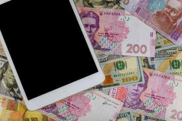Money dollars and hryvnia, on digital devices tablet with e-commerce concept finance