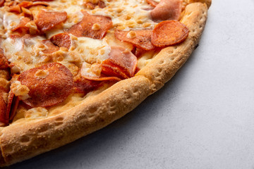 Delicious hot homemade Pepperoni pizza on the wooden table. Pepperoni Pizza - Fresh homemade pizza with pepperoni, cheese and tomato sauce on rustic black stone background with copy space.