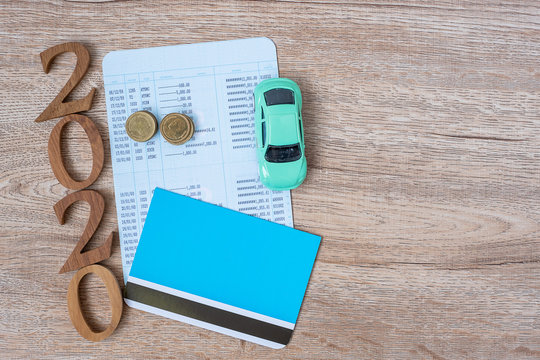 2020 Happy New Year With Book Bank And Car On Wood Table Background With Copy Space. Financial, Money, Refinance, Car For Cash And Car Insurance Concept