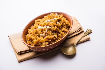 Wheat Laapsi/Lapsi/Shira/Halwa is an Indian sweet dish made of broken wheat or Daliya pieces and ghee along with nuts, raisins and dried fruits. It's a healthy food. served in a bowl, selective focus