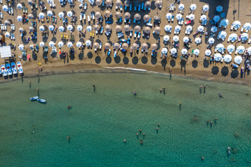 Aerial top view photo of sun beds and umbrellas in popular tropical paradise deep turquoise...