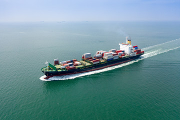 Aerial view of the large volume of TEU container on ship sailing to the sea carriage the shipment from loading port to destination