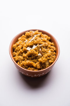 Wheat Laapsi/Lapsi/Shira/Halwa is an Indian sweet dish made of broken wheat or Daliya pieces and ghee along with nuts, raisins and dried fruits. It's a healthy food. served in a bowl, selective focus