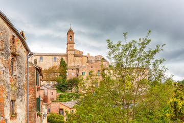 Old Italian rural village on a hill with dark rain clouds